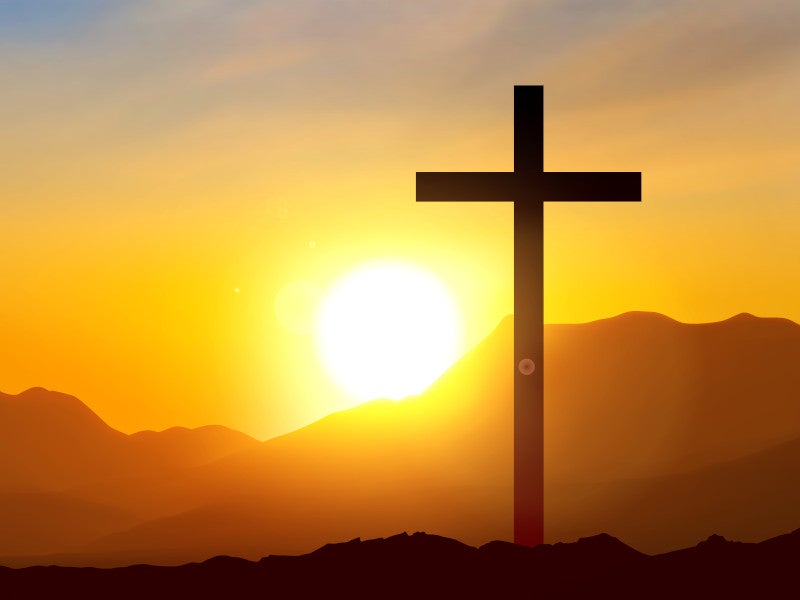 A cross silhouette stands against a vibrant sunset, with the sun glowing in the background.